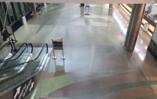 Overhead view of a dirty waxed, terrazzo floor. All the colors in the floor are dull.