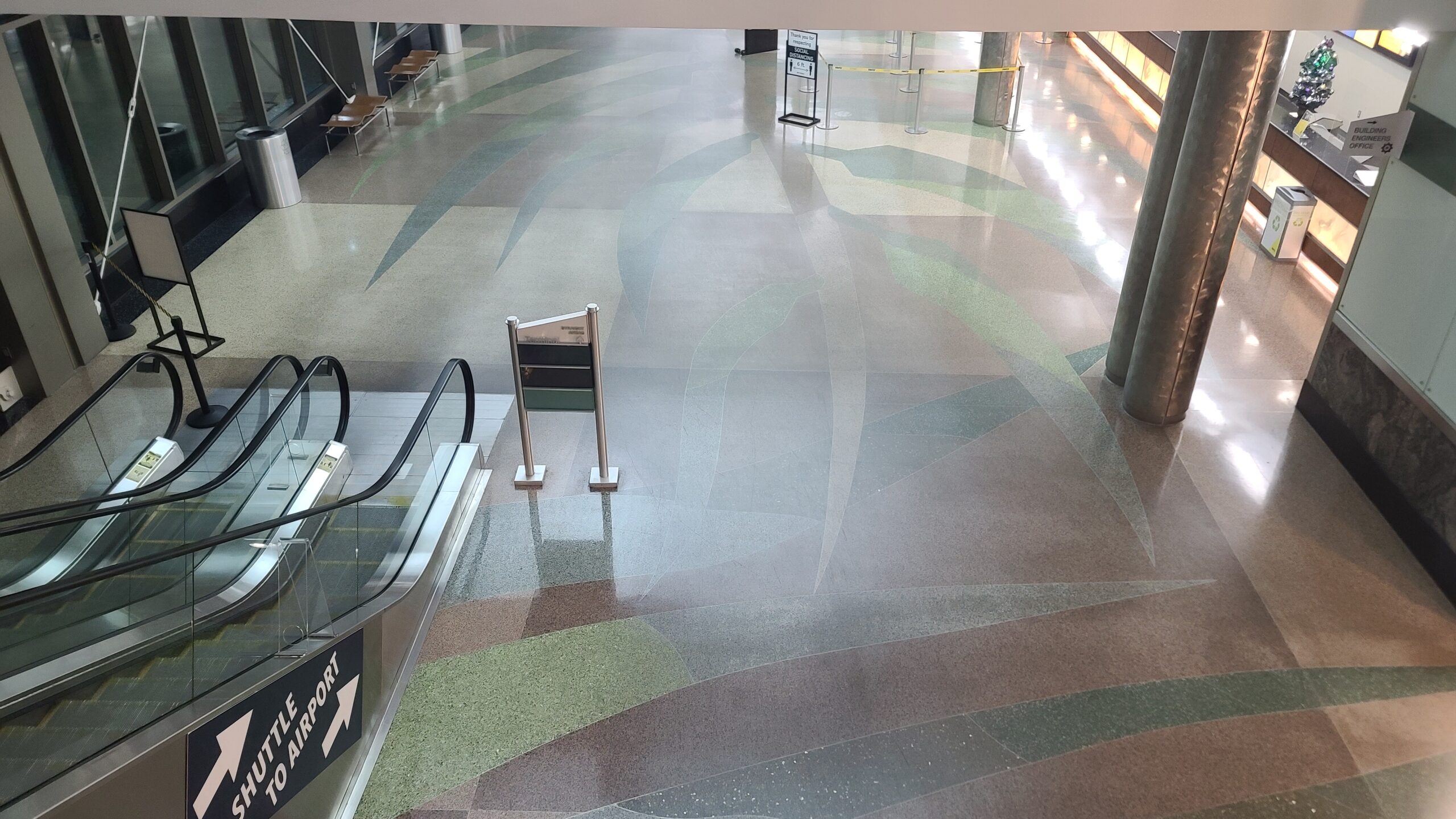 Overhead view of a dirty waxed, terrazzo floor. All the colors in the floor are dull.