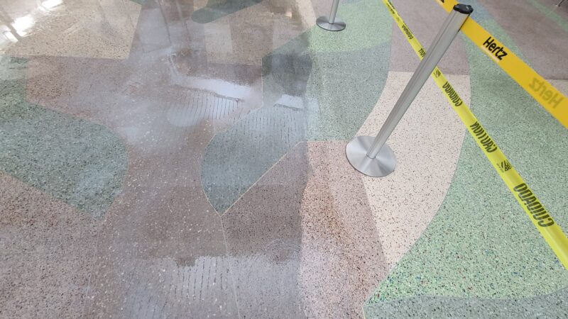 Close up of a floor during the stripping process. Old finish very dark and dull. Floor with no finish is very bright.